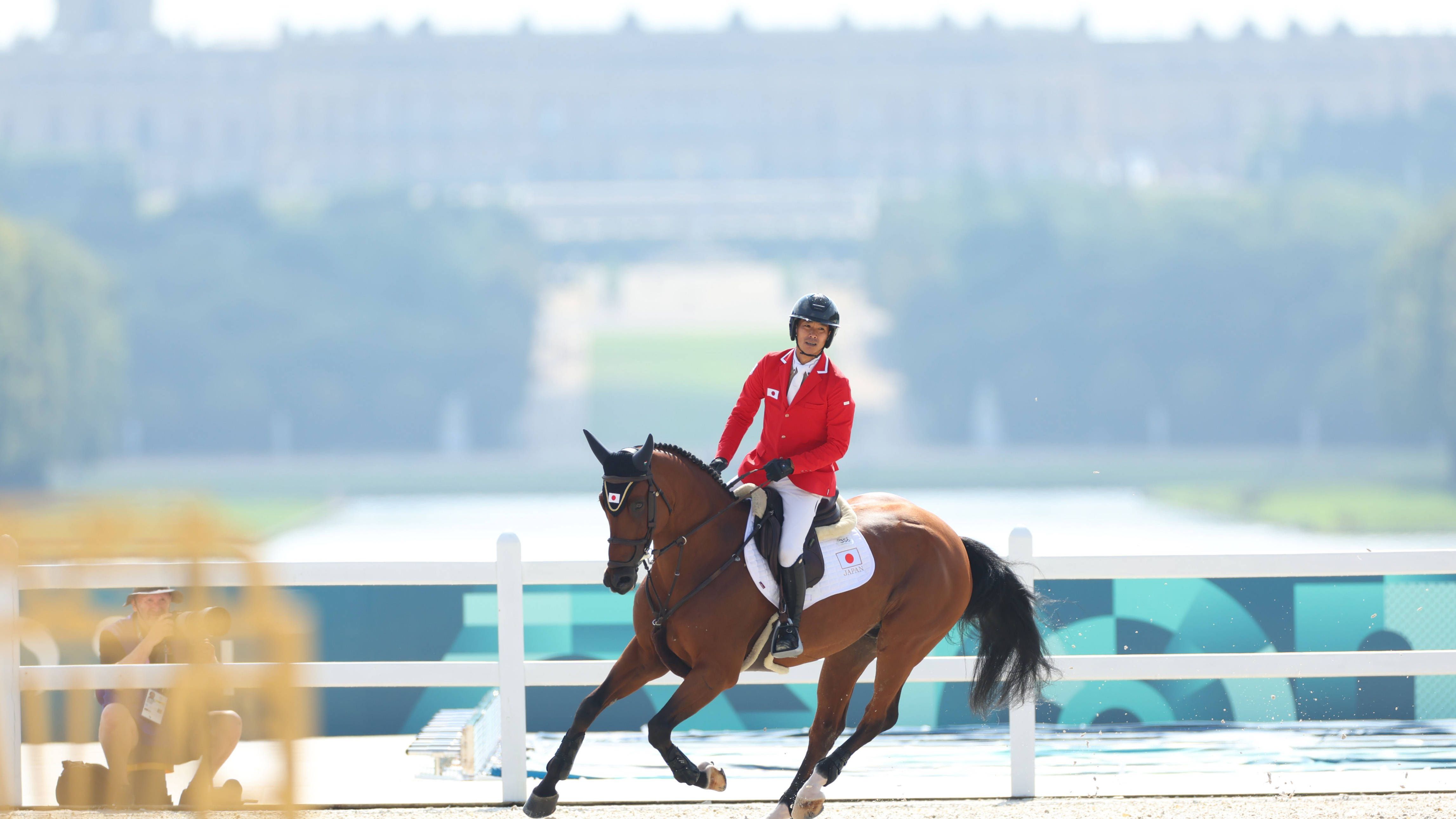 <strong>Olympia 2024: Die besten Bilder des sechsten Tages</strong><br>Der Japaner Taizo Sugitani mit seinem Pferd auf dem Parcours, im Hintergrund: Versailles.