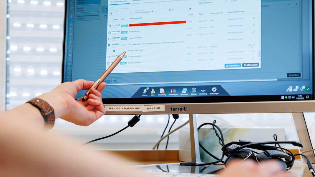 Ein Hausarzt lädt in seiner Praxis Dokumente in eine elektronische Patientenakte "ePA". 