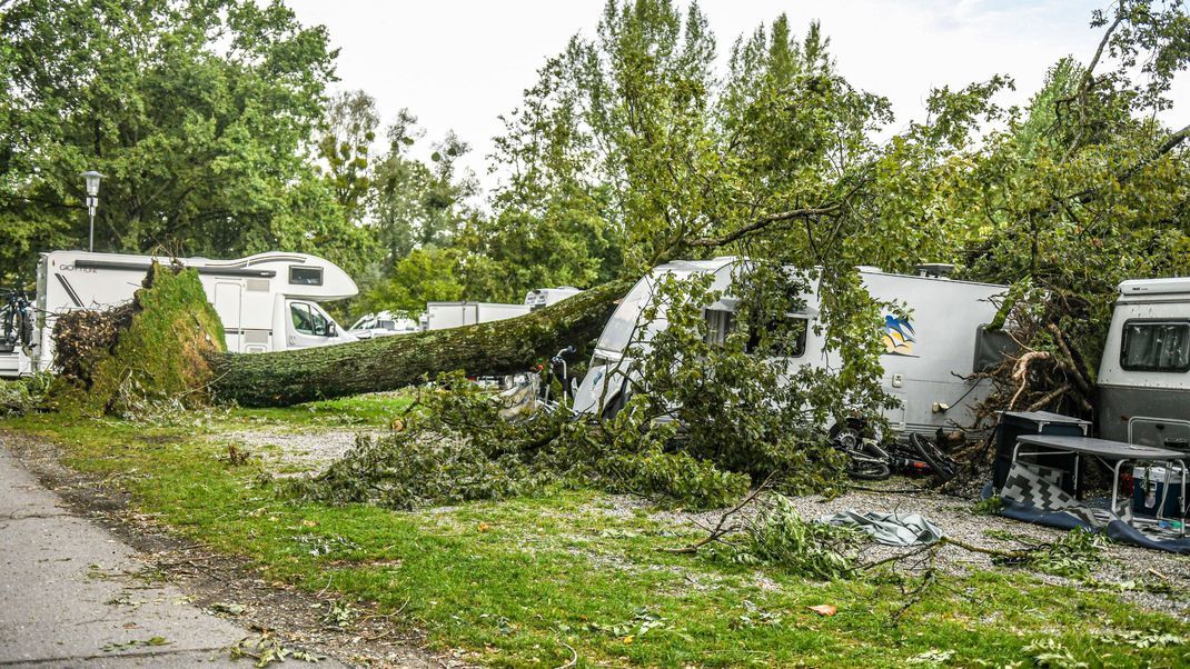 Bayern, Lindau: Umgestürzte Bäume und Äste liegen auf einem Wohnwagen auf einem Campingplatz. 