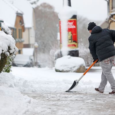 Archiv: Mit einem Schneeschieber räumt ein Anwohner in Schierke den Schnee vom Gehweg. 