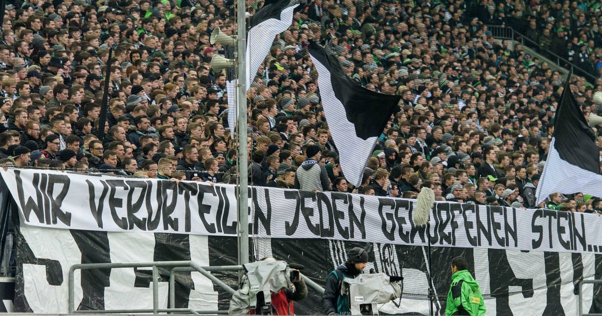 
                <strong>Banner der Gladbach Fans</strong><br>
                Nächstes geschmackloses Plakat gegen die Fans von RB Leipzig. Nachdem sich der Protest der Anhänger von Borussia Mönchengladbach beim Heimspiel gegen RB am Sonntag zunächst auf 19 Minuten Schweigen und einige nicht beleidigende Plakate beschränkte, wurde in der Borussia-Kurve jedoch folgendes Banner hochgehalten: "Wir verurteilen jeden geworfenen Stein...". Vervollständigt wurde der Satz von einem zweiten Banner: "... der euch Kunden nicht getroffen hat". Eine mögliche Bestrafung durch den DFB könnte demnach also auch für den Klub vom Niederrhein folgen.
              