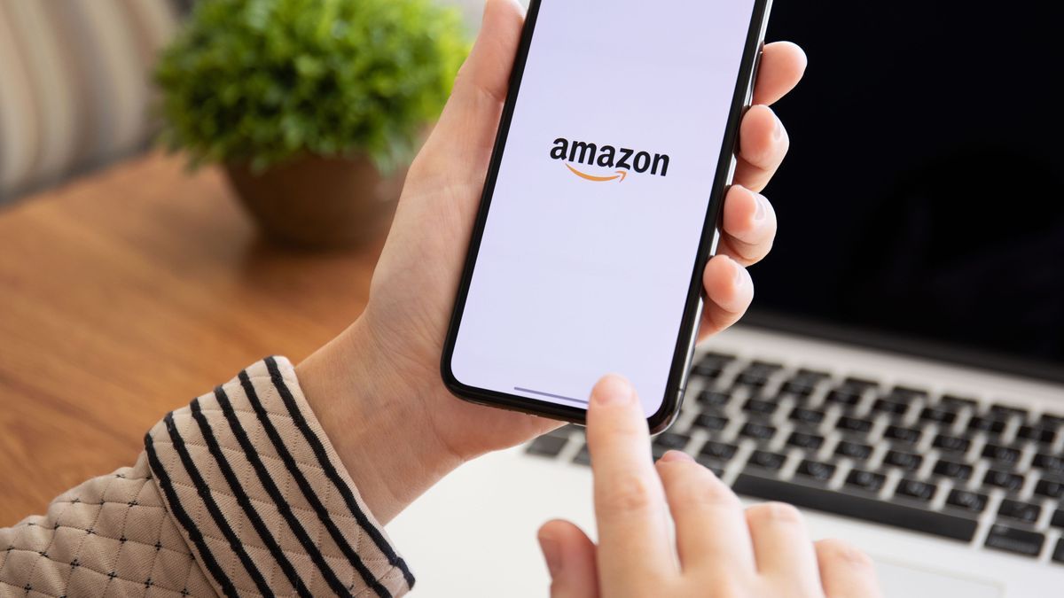 Woman holding iPhone X with Internet shopping service Amazon