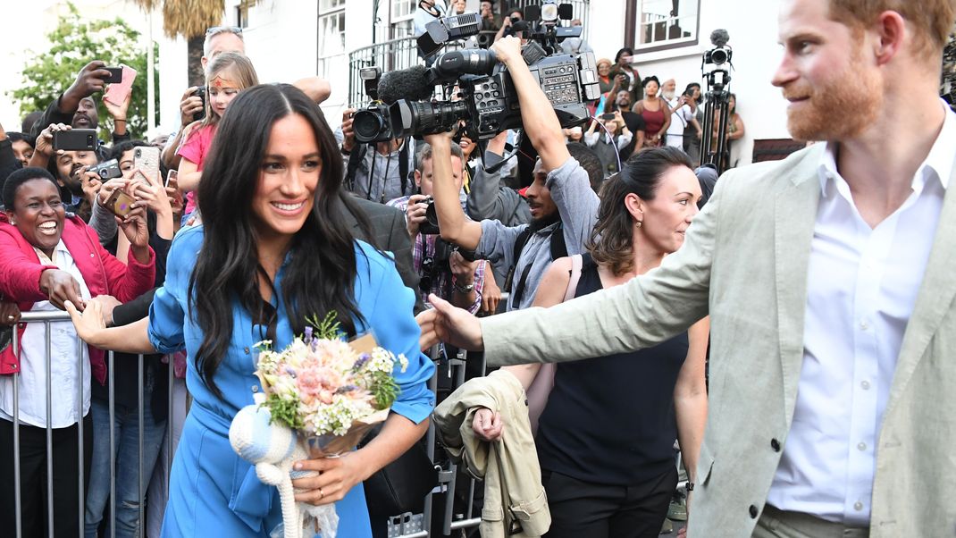 Auf einem royalen Besuch in Afrika begrüßen Harry und Meghan Schaulustige. Immer dabei: Massen von Fotografen und Kamerateams.