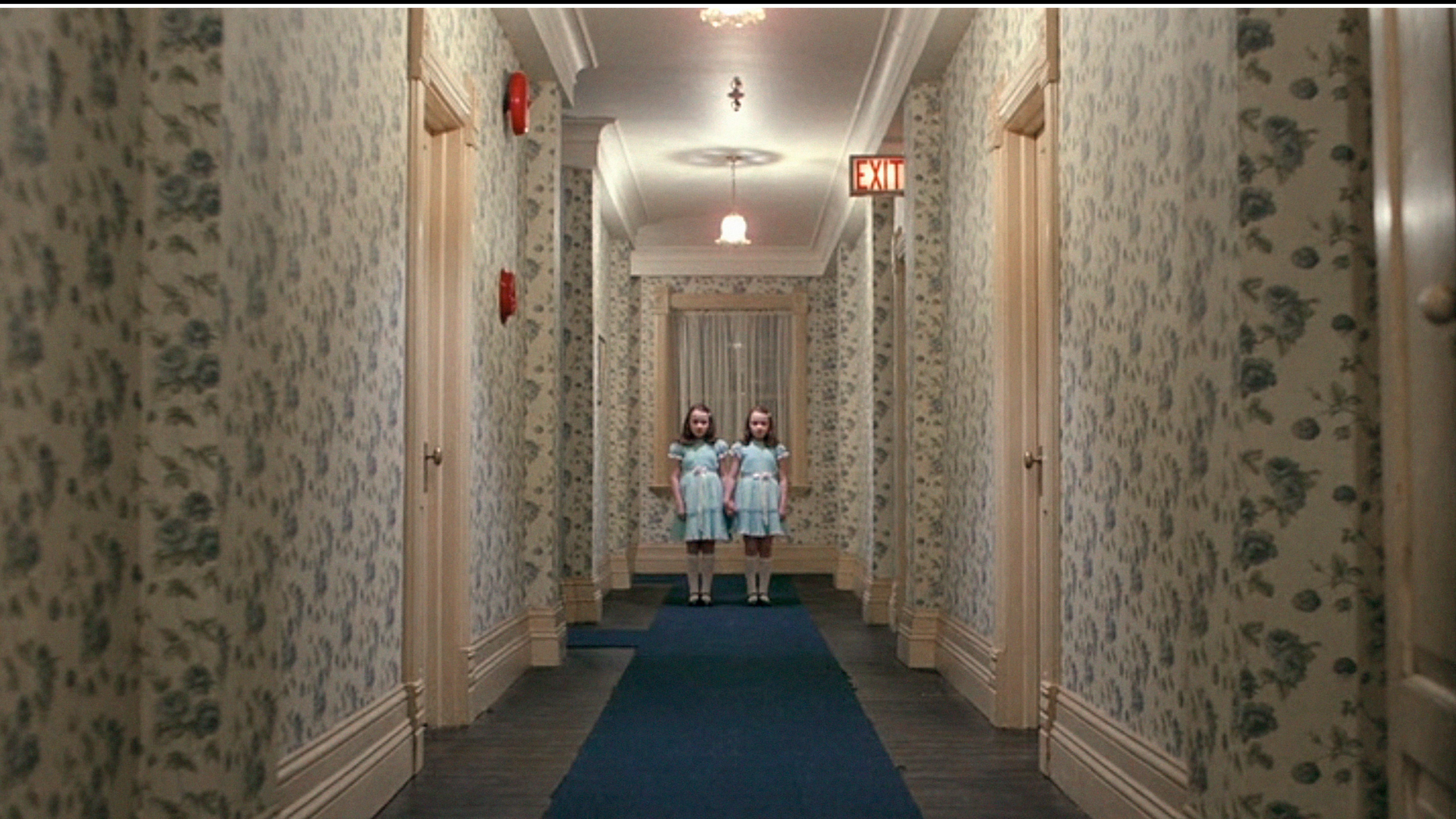 In "The Shining" stößt der kleine Danny Torrance in den endlosen Fluren des Overlook Hotels auf die Zwillinge, deren leere Blicke und unheimlich synchronisiertes Lächeln, gepaart mit blutigen Visionen bis heute für Gänsehaut sorgen.