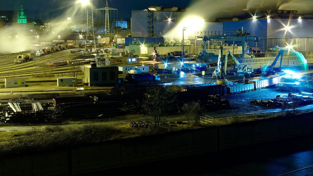 Steel hut in Völklingen in the Saarland in Germany at night in the foreground the Autonahn a620 and the river Saar, the photo shows the production of steel from scrap loaded in railway wagons