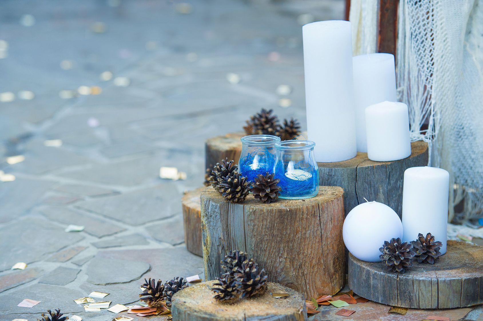 Adventsgestecke-Ideen können ruhig etwas ausgefallen sein. Besonders natürlich wirken Kerzen auf einem Baumstamm.