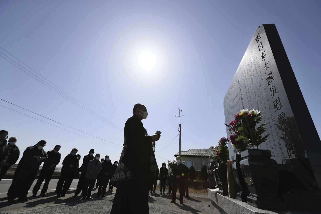 Am 10. Jahrestag des fatalen Tsunamis und der Reaktor-Katastrophe im Kernkraftwerk Fukushima Daiichi beten Menschen an einem Ehrenmal für die Opfer.