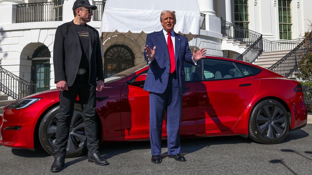 US-Präsident Donald Trump (r) und Tesla-CEO Elon Musk sprechen im März zu Reportern vor einem roten Tesla Model S.