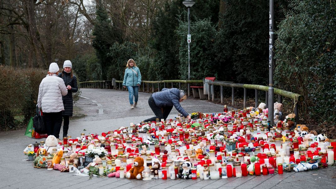 Eine Person legt einige Tage nach dem tödlichen Messerangriff Blumen im Park nieder.