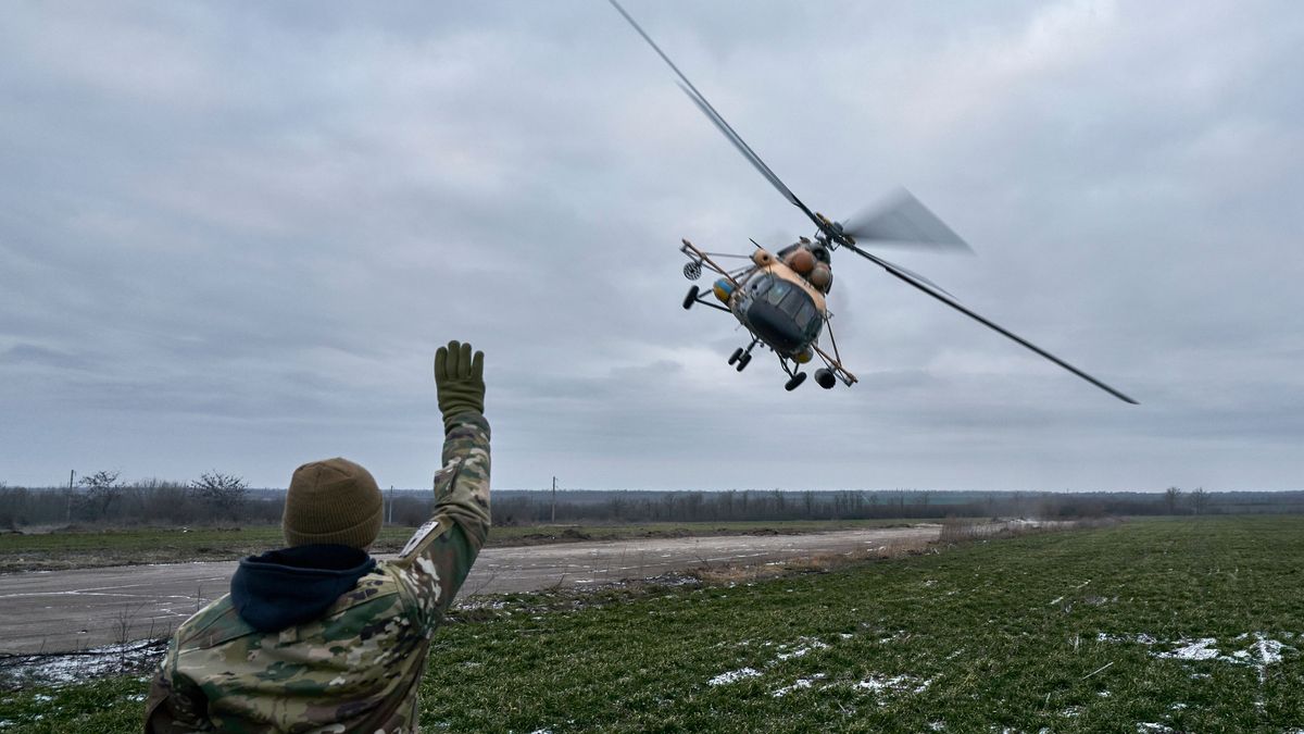 Ein ukrainischer Soldat winkt einem Militärhubschrauber in Cherson zu.