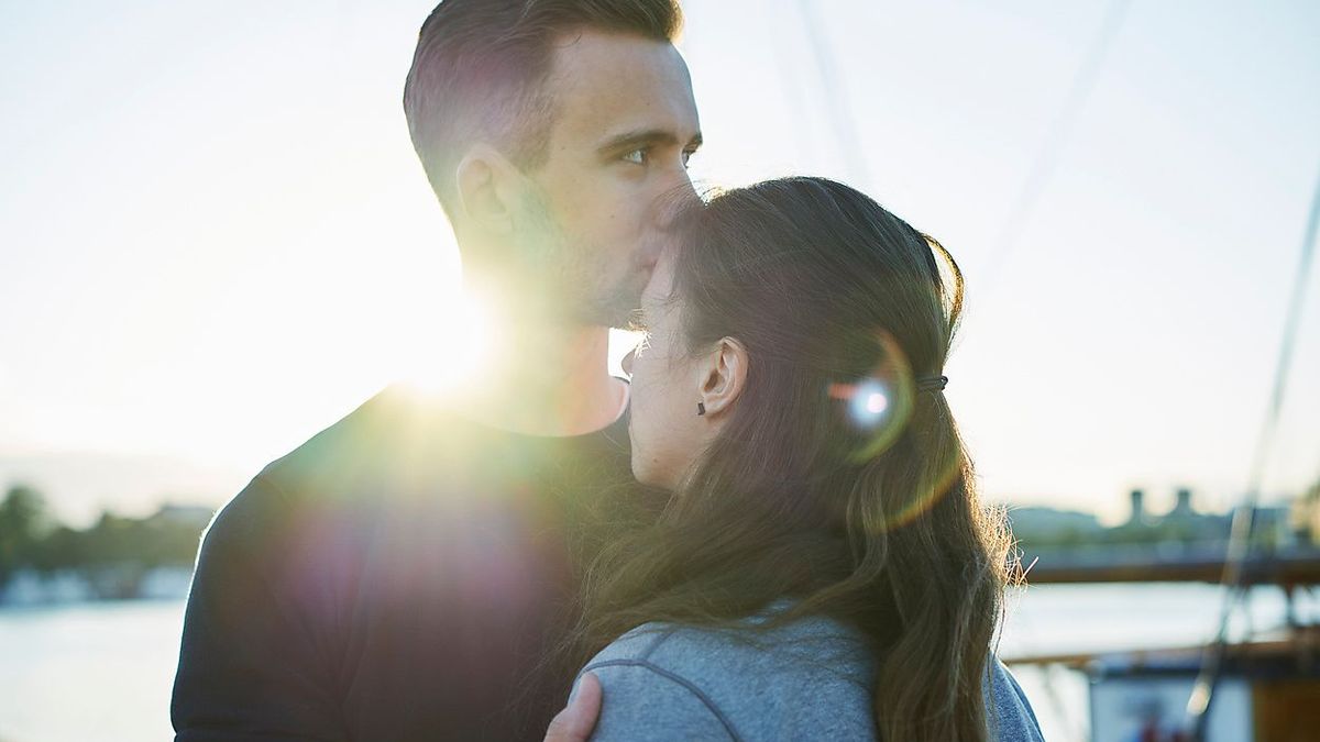 Young man kissing woman´s forehead outdoors in Stockholm