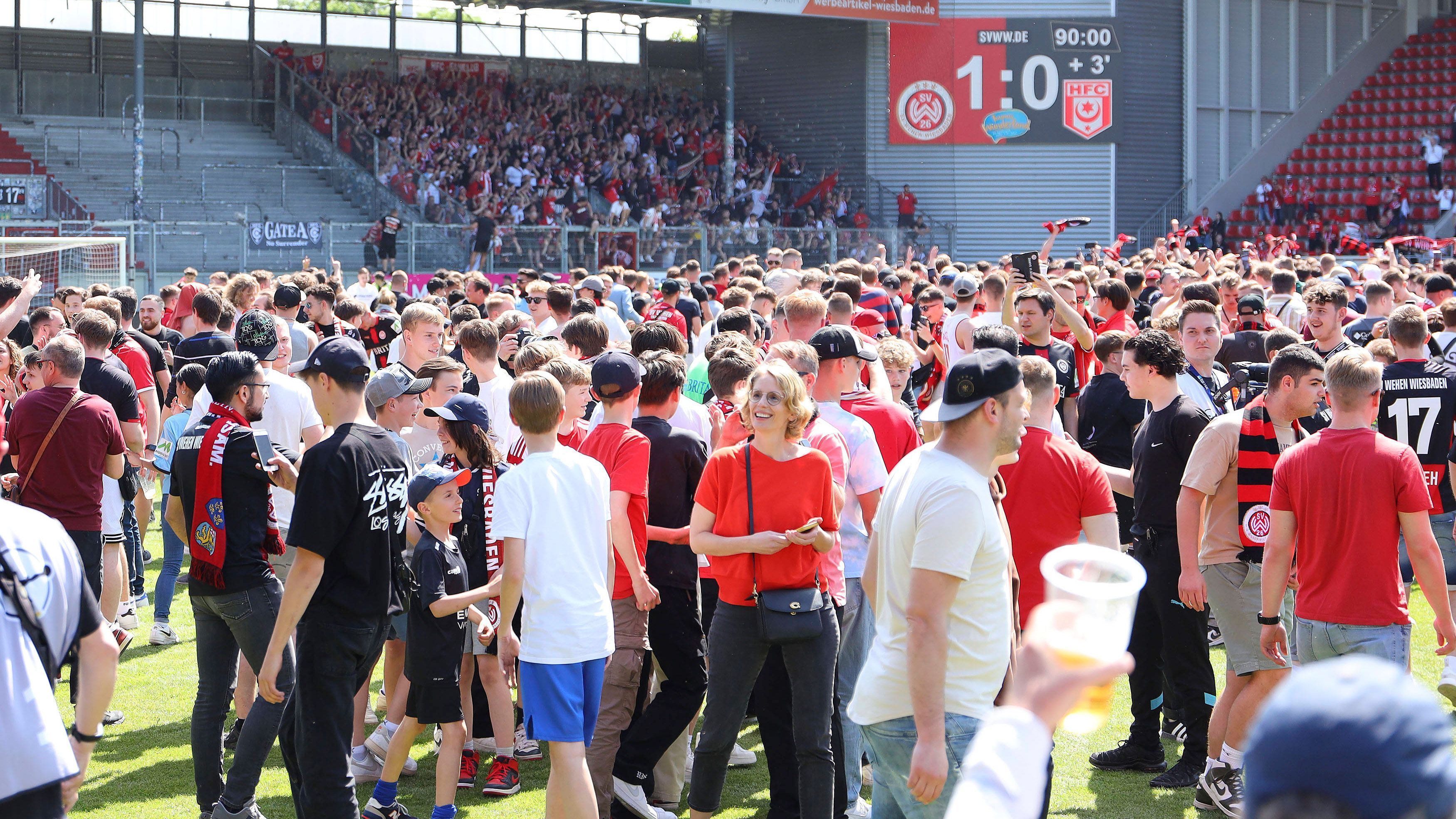 
                <strong>Verfrühter Platzsturm</strong><br>
                Die Szenen nach Schlusspfiff in Wiesbaden erinnerten an die "Meisterschaft der Herzen" von Schalke 04 im Jahr 2001 oder an den ebenfalls verfrühten Platzsturm des HSV in Sandhausen am vergangenen Wochenende. Nach dem 1:0-Sieg gegen den Halleschen FC wähnten sich die Hessen schon in der 2. Bundesliga, der Platz wurde gestürmt, Spieler und Fans lagen sich in den Armen, die Social-Media-Abteilung twitterte voreilig. Doch in Osnabrück wurde noch gespielt - und der VfL machte durch Tore in der vierten und sechsten Minute der Nachspielzeit aus einem 0:1 gegen Borussia Dortmund II noch ein 2:1 und zog an Wehen Wiesbaden vorbei. Der Elf von Trainer Markus Kauczinski fehlte am Ende ein Tor - schon mit einem 2:0 gegen Halle wäre Wehen Wiesbaden vor dem VfL Osnabrück gelandet.
              