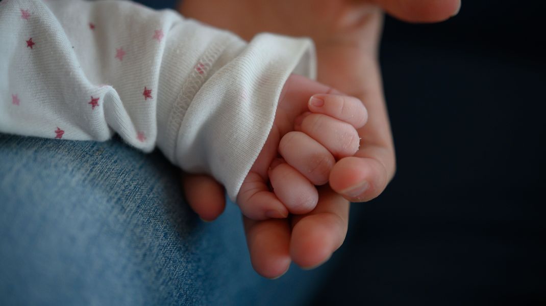 Die Hand eines zwei Wochen alten Neugeborenen in der Hand seiner Mutter (Symbolbild).