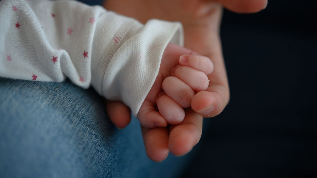 Die Hand eines zwei Wochen alten Neugeborenen in der Hand seiner Mutter (Symbolbild).