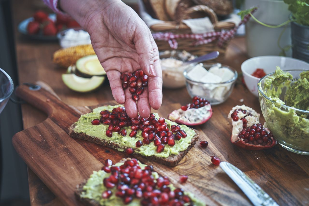 Es muss nicht immer kompliziert sein: Vollkorn-Brot mit zermatschter Avocado, Granatapfel-Kernen und eine Prise Salz und Pfeffer.