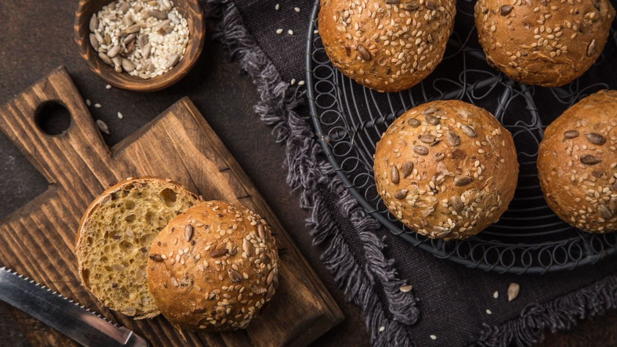 fresh baked buns with sesame, sunflower and flaxseed, wooden background