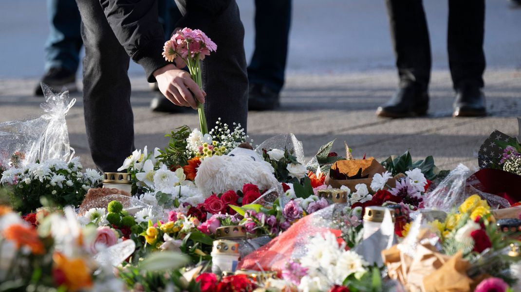 Ein Passant legt Blumen vor dem Eingang der Johanniskirche an einer Andachtsstätte nieder. 