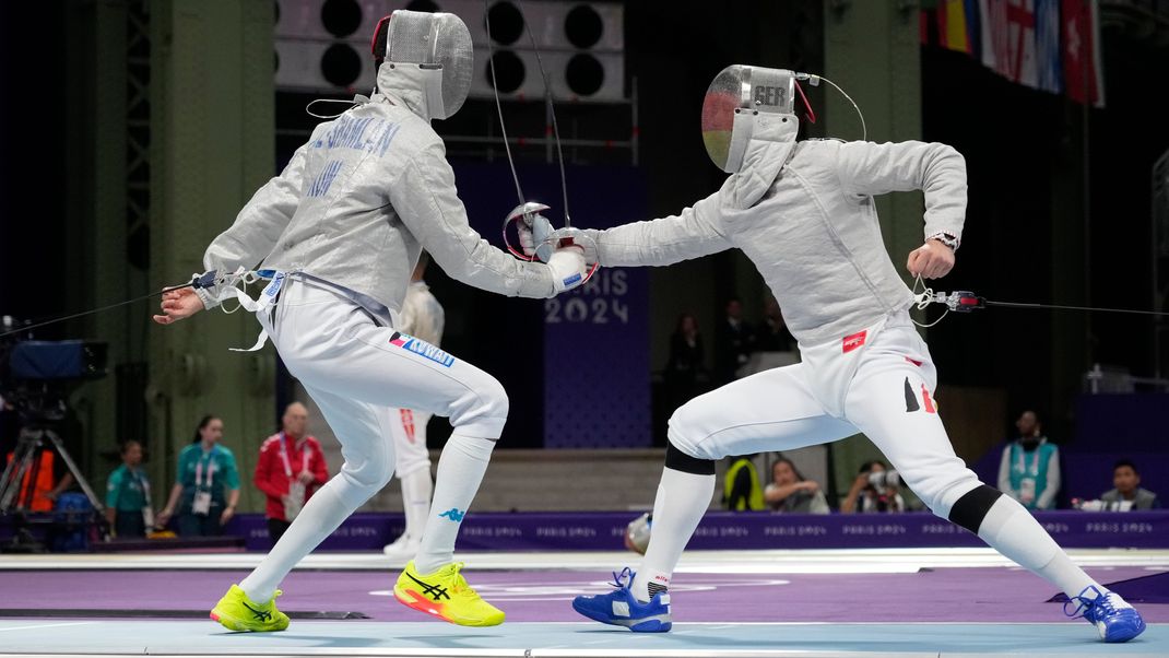 27. Juli 2024, Frankreich, Paris: Yousef Alshamlan (links, Kuwait) und Deutschlands Matyas Szabo treten während der Olympischen Sommerspiele 2024 im Grand Palais in der Runde der letzten 32 im Säbel-Einzelwettbewerb der Männer an.