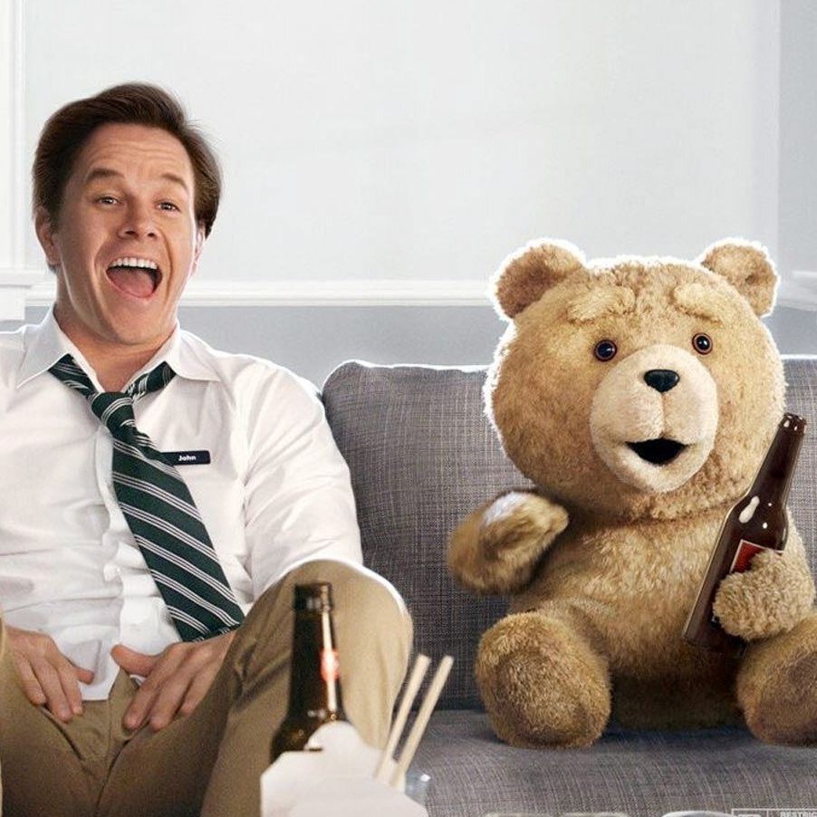 Filmposter des Erfolgsfilms "Ted". Mark Wahlberg und Ted sitzen mit Fastfood und Bier auf der Couch und schauen fernn.
