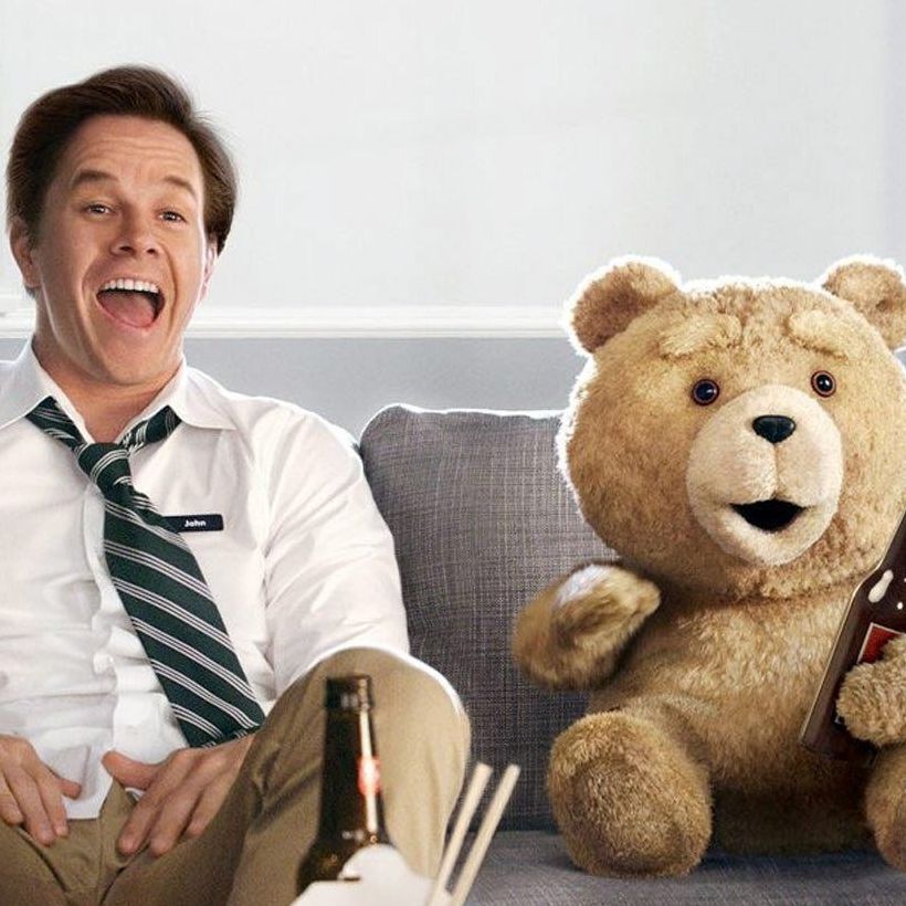 Filmposter des Erfolgsfilms "Ted". Mark Wahlberg und Ted sitzen mit Fastfood und Bier auf der Couch und schauen fernn.
