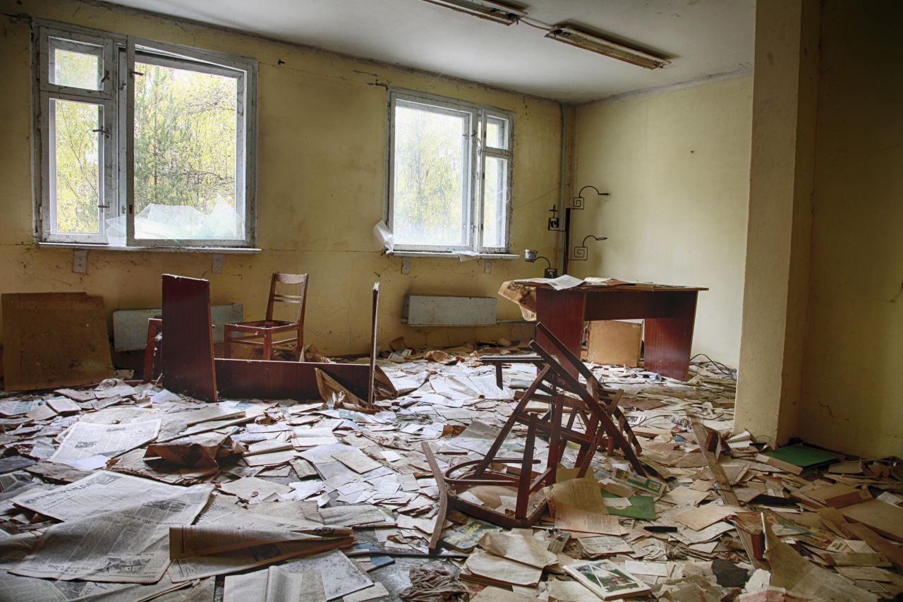 Zeitungen und Bücher verstreut auf dem Boden, zerbrochene Bänke und Stühle. In diesem Klassenzimmer einer ehemaligen Schule in Prypjat fand 1986 der letzte Unterricht statt. Im Lauf der Jahre nahm die Natur den Ort in Besitz – in manchen Räumen wachsen Bäume.