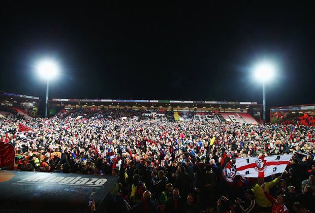 
                <strong>AFC Bournemouth: Der märchenhafte Aufstieg eines Fußball-Zwerges</strong><br>
                Die Fans sind kaum noch zu halten, als sich die "Cherries" am 45. Spieltag der League Championship bei den Bolton Wanderers mit einem 3:0-Erfolg den Aufstieg in den englischen Fußball-Olymp sichern. 
              
