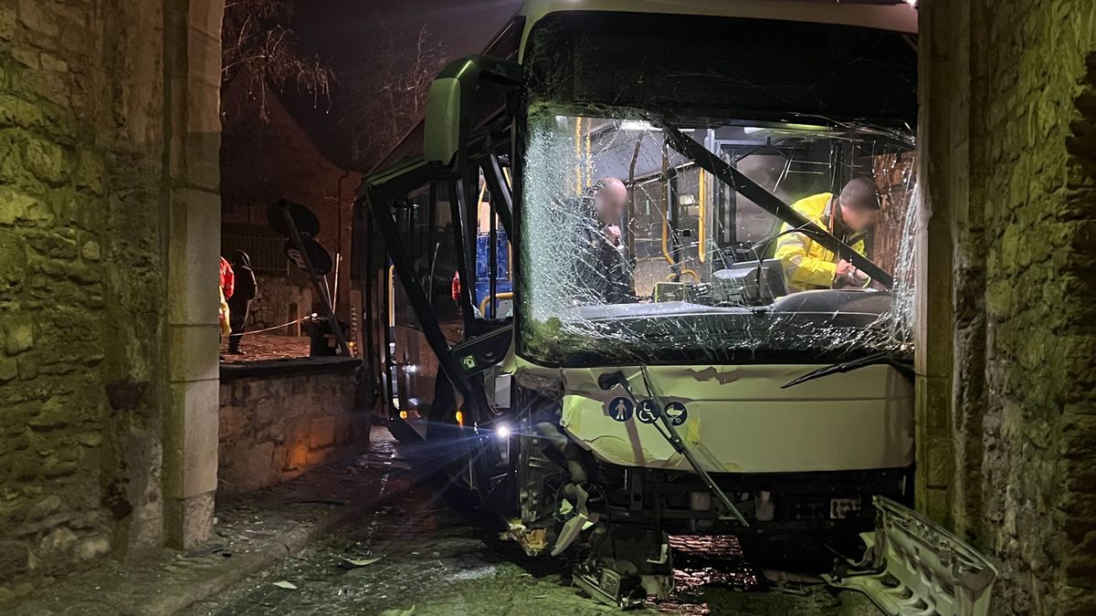 Am Mittwochmorgen steht in Sommerhausen im Landkreis Würzburg ein schwer beschädigter Bus in einem Torbogen.