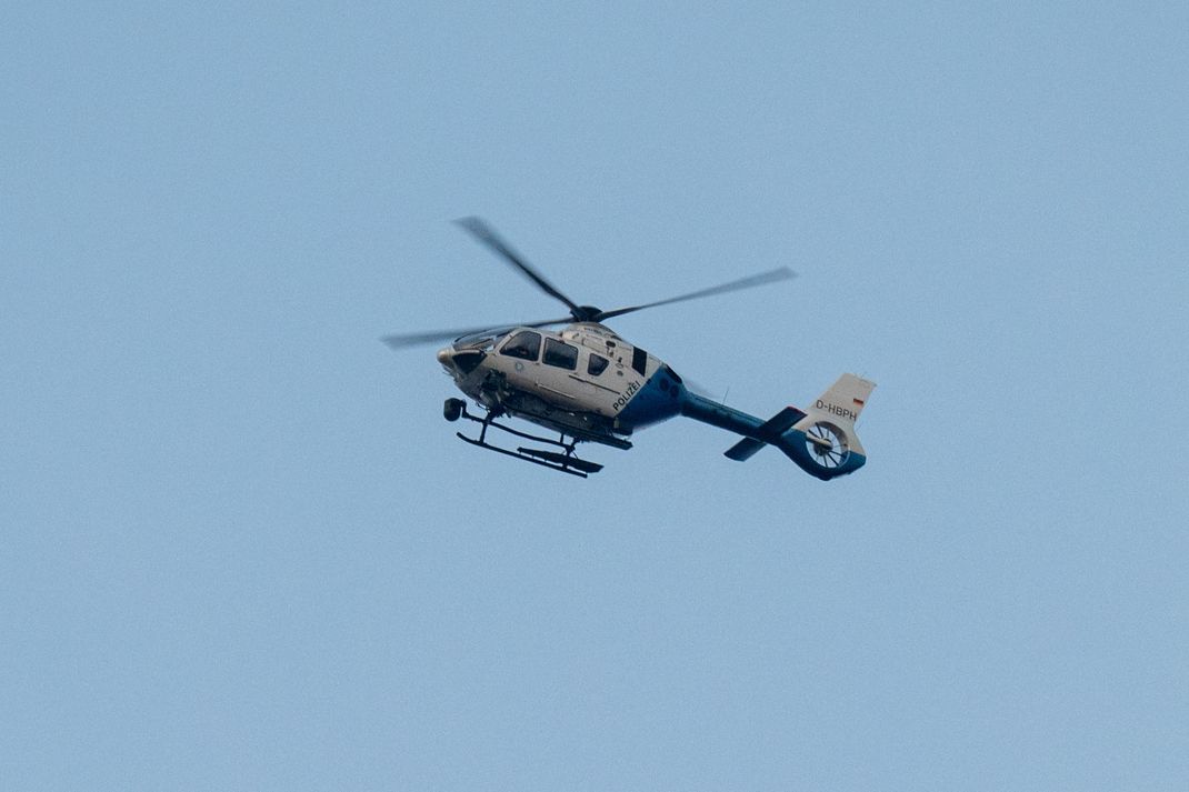 Mit einem Polizeihubschrauber wird nach den Täter:innen gesucht.