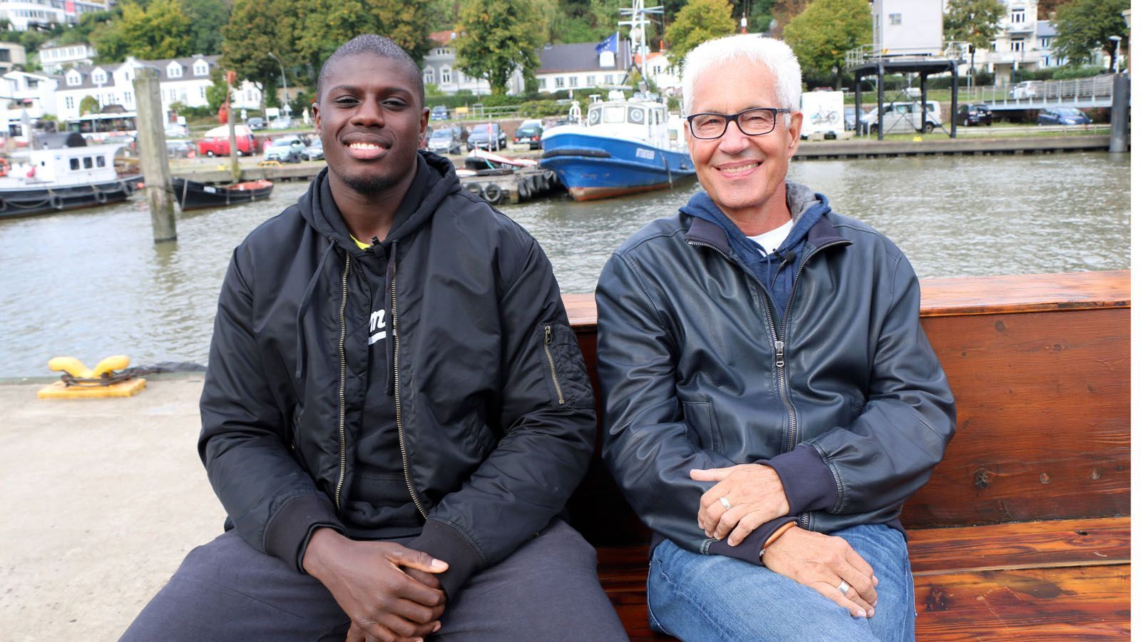 
                <strong>Das ist Peter Kadiru</strong><br>
                Seine bisherigen Erfolge können sich sehen lassen. Kadiru, der von Klitschko-Manager Bernd Bönte (r.) betreut wird, hat als Amateur und Junior quasi alles gewonnen. 2014 holte er Olympisches Gold bei den Jugendspielen. Nun ist Kadiru seit zwei Jahren Profi und hat in diesem Jahr in vier Kämpfen zwei Gürtel gewonnen. Die Belohnung ist jetzt das Sparring-Training mit Joshua. 
              