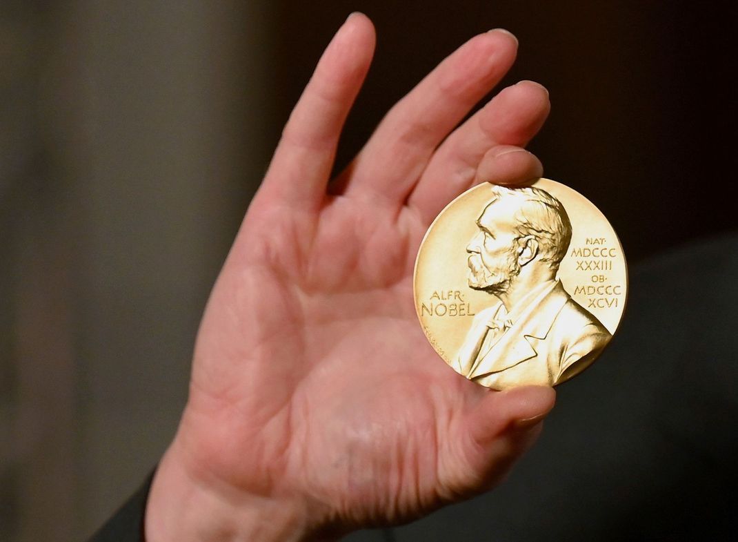Eine Nobelmedaille wird während einer Zeremonie in New York hochgehalten. 