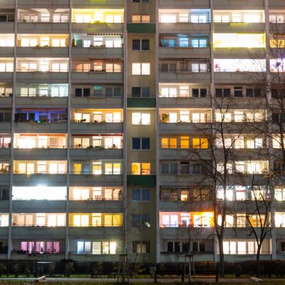 In einem Hochhaus in Berlin-Lichtenberg sind einige Fenster beleuchtet.