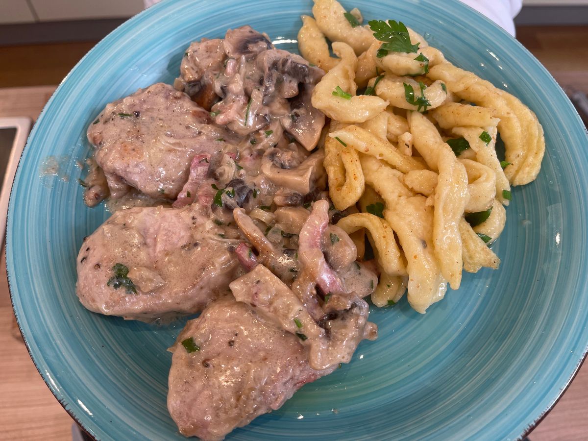 Gegrilltes Schweinekottelet mit roten Zwiebeln auf Cognac-Pfeffersoße ...