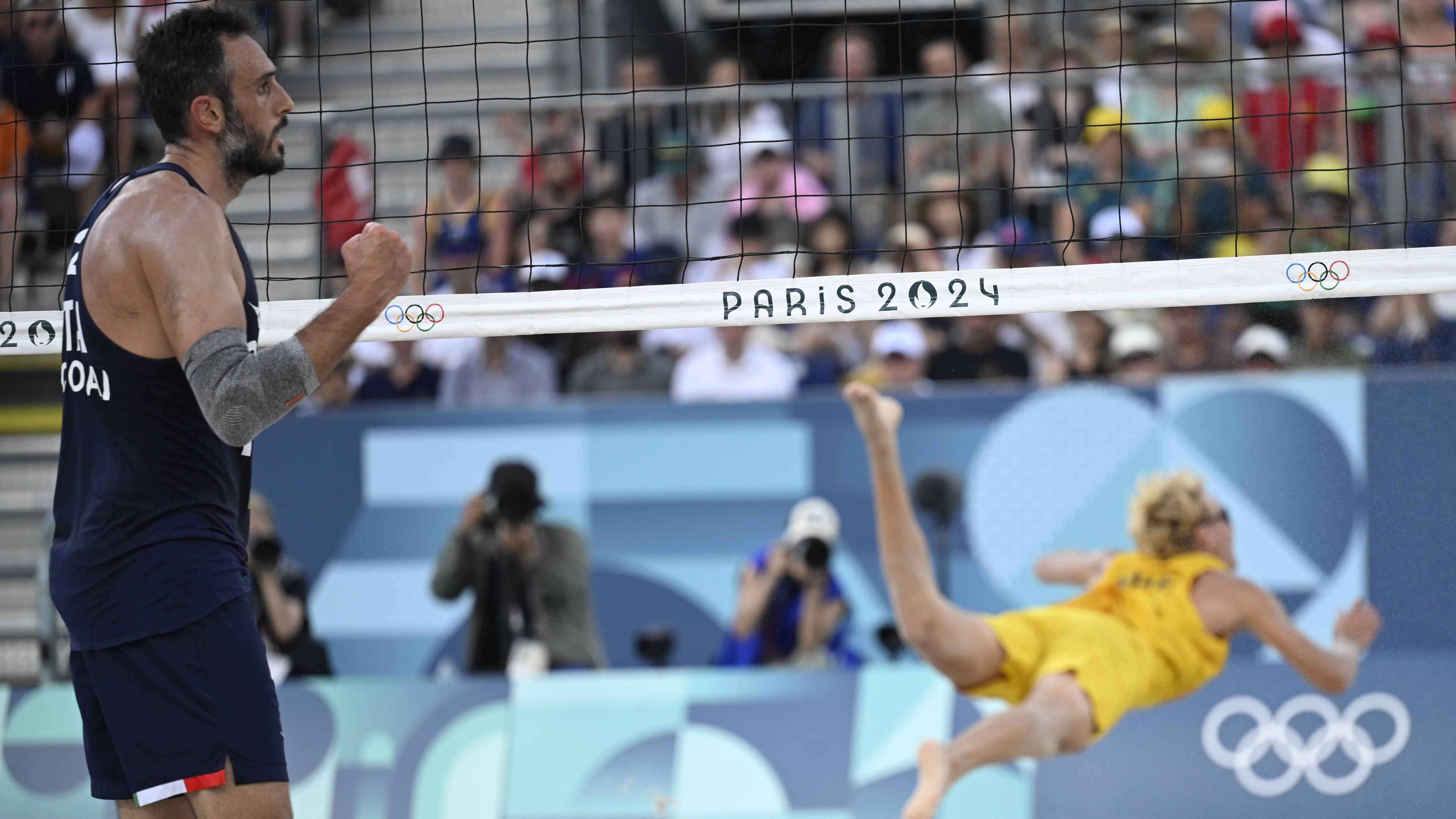 <strong>Olympia 2024: Die besten Bilder des sechsten Tages</strong><br>Während Schwedens David Ahman noch fliegt, setzen die italienischen Beachvolleyballer um Samuele Cottafava und Paolo Nicolai bereits zum Jubel an.