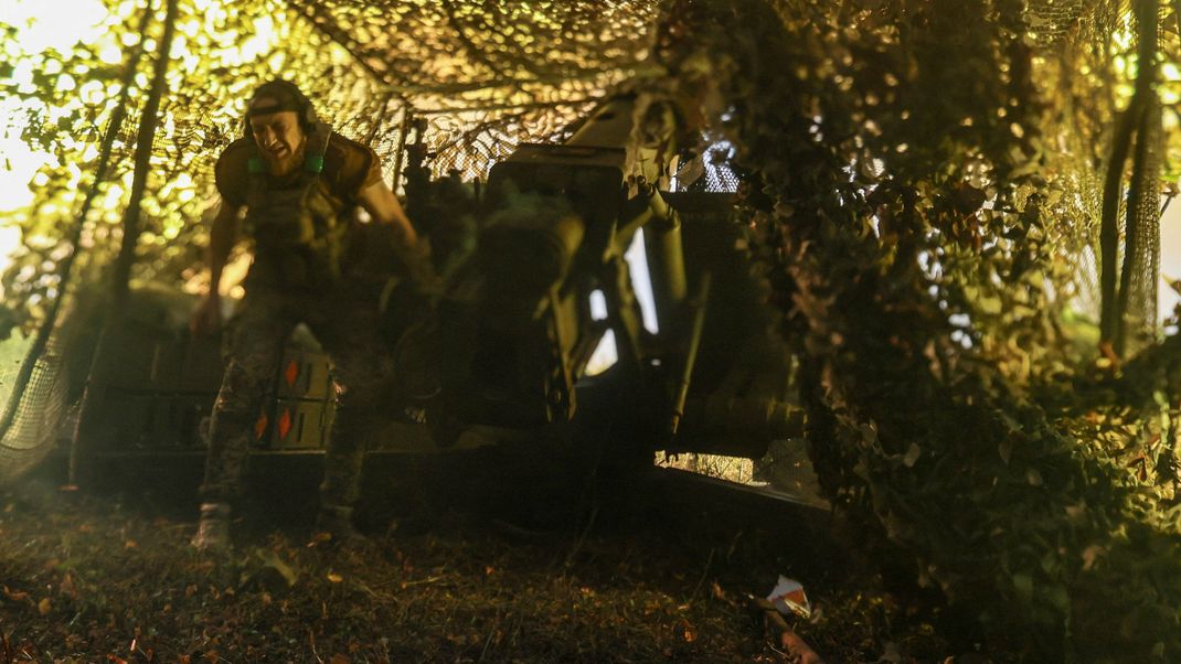 Ein ukrainischer Soldat feuert eine Haubitze auf russische Stellungen ab. 