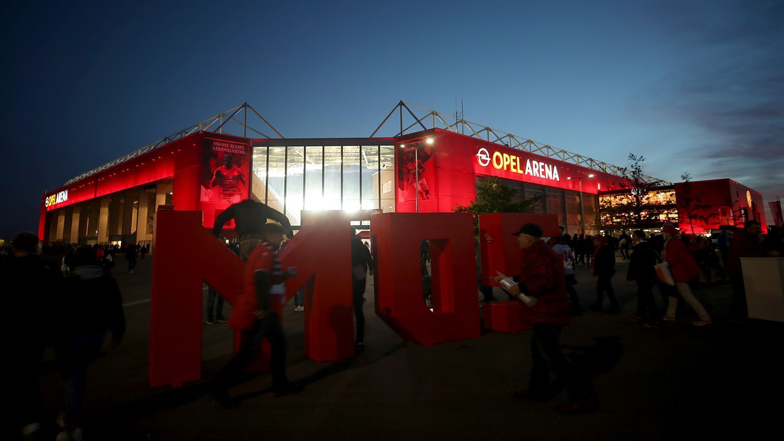 
                <strong>1. FSV Mainz 05: Verworfene Baupläne und Kaltluftschneise</strong><br>
                Die Besucher der Opel-Arena in Mainz sollten an wetterfeste Kleidung denken. Das Stadion liegt nämlich direkt in einer Kaltluftschneise, die dafür sorgt, dass regelmäßig ein rauer Wind über die Tribünen fegt. Eigentlich wollte der FSV ein neues, größeres Stadion bauen, konnte sich aber auf keinen Standort festlegen. Zwischenzeitlich wurde sogar überlegt, eine gemeinsame Arena mit dem SV Wehen Wiesbaden zu bauen.
              