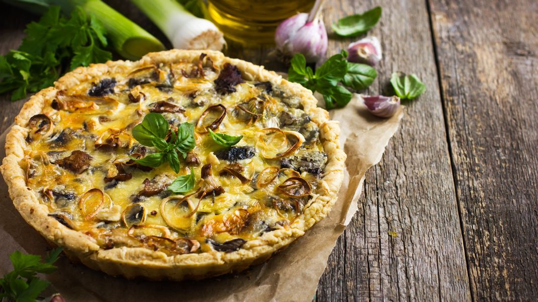 Eine herbstliche Quiche mit frischen Pilzen.