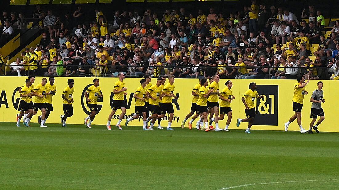 
                <strong>Der Trainingsauftakt von Borussia Dortmund</strong><br>
                Borussia Dortmund beginnt die Vorbereitung auf die neue Saison ohne die Neuzugänge Karim Adeyemi, Niklas Süle, Nils Schlotterbeck und Salih Özcan. Auch der verletzte Kapitän Marco Reus fehlt. Dennoch strömen etwa 1300 Fans zum Trainingszentrum in Dortmund Brackel.
              