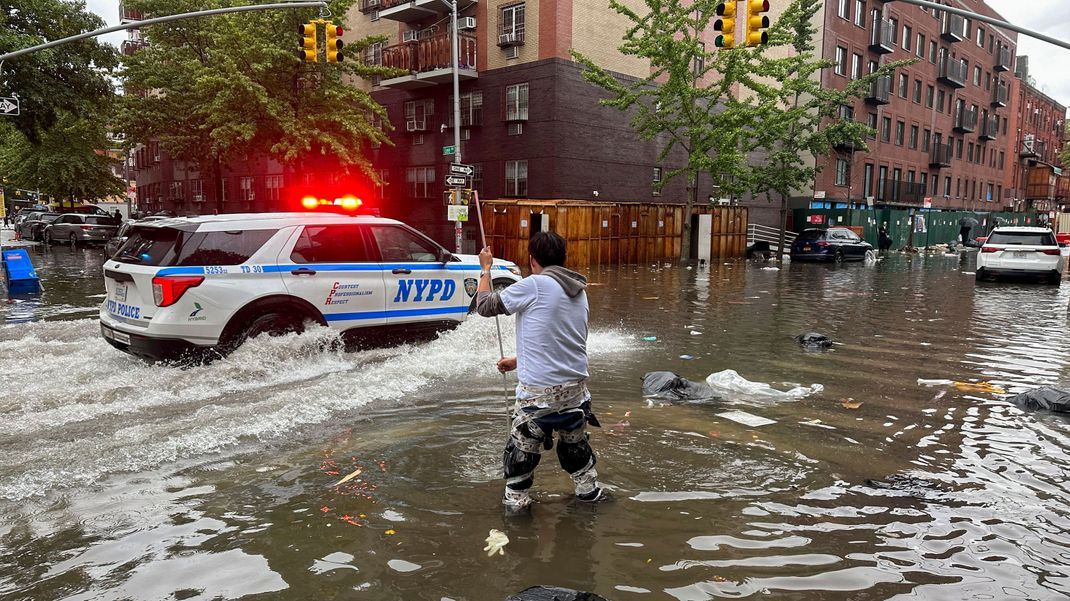 USA, New York: Ein Mann versucht im Stadtbezirk Brooklyn einen Abfluss im Hochwasser zu reinigen.&nbsp;
