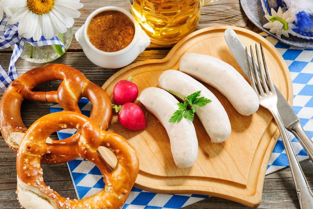 Mmmh... Lecker! Mit Brezn und Weißwürsten können Sie es sich auf der Oktoberfest-Party richtig gut gehen lassen.