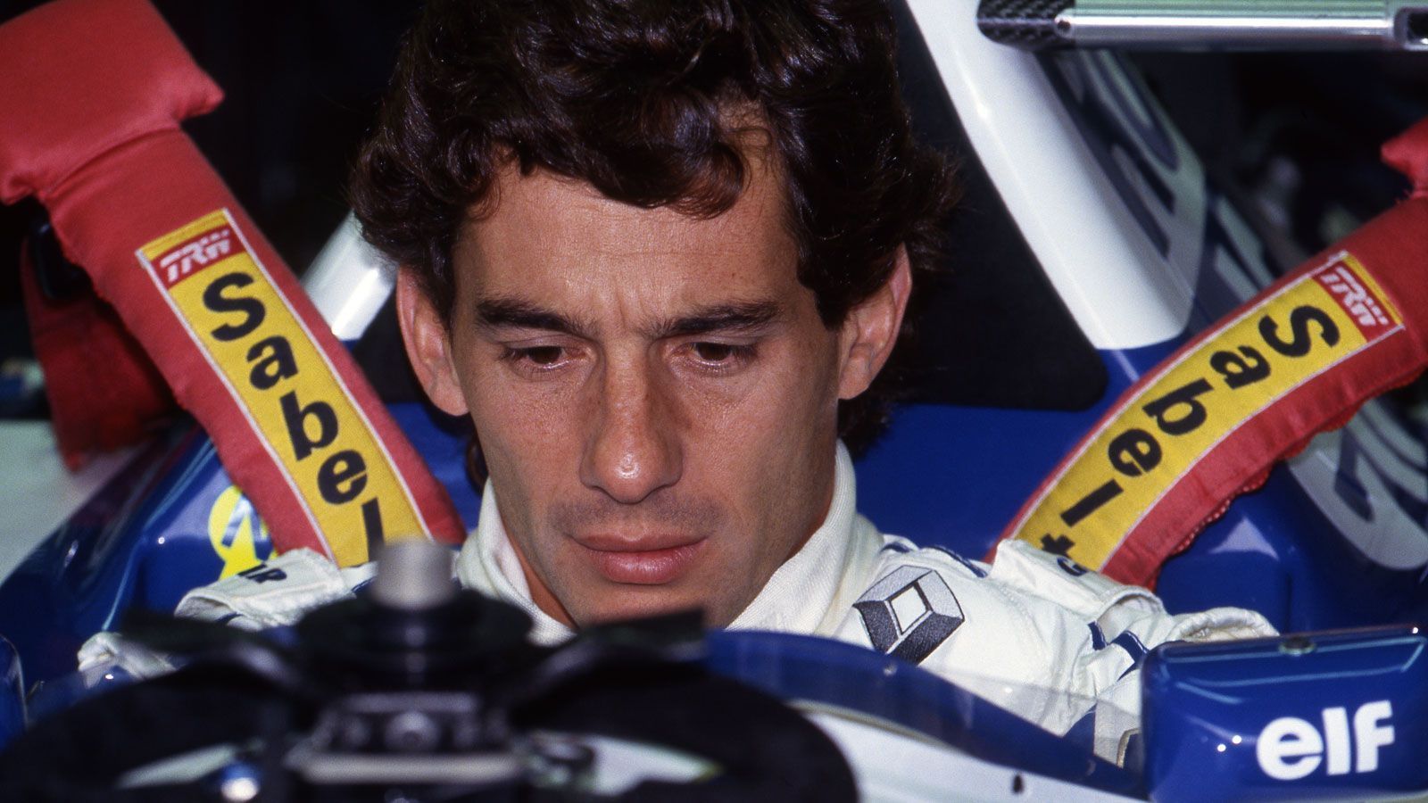 
                <strong>Ayrton Sennas letztes Rennen</strong><br>
                Das Rennen am Sonntag wurde dann von Sennas tödlichem Unfall überschattet. Der dreimalige Weltmeister und Fanliebling ging von der Pole Position ins Rennen und führte dieses bis zu seinem Abflug in der siebten Runde auch an. Kurz nach einer langen Safety-Car-Phase flog Senna in der schnellen Tamburello-Kurve ab und prallte mit über 200km/h in spitzem Winkel gegen eine Betonmauer. Bei dem Aufprall löste sich ein Teil der Vorderradaufhängung und verletzte den Brasilianer schwer am Kopf, der mit seinem Auto zurück auf die Strecke trudelte. Senna wurde nach Bologna in ein Krankenhaus geflogen, dort verkündete die behandelnde Ärztin dann am frühen Abend den Tod des Star-Piloten.
              