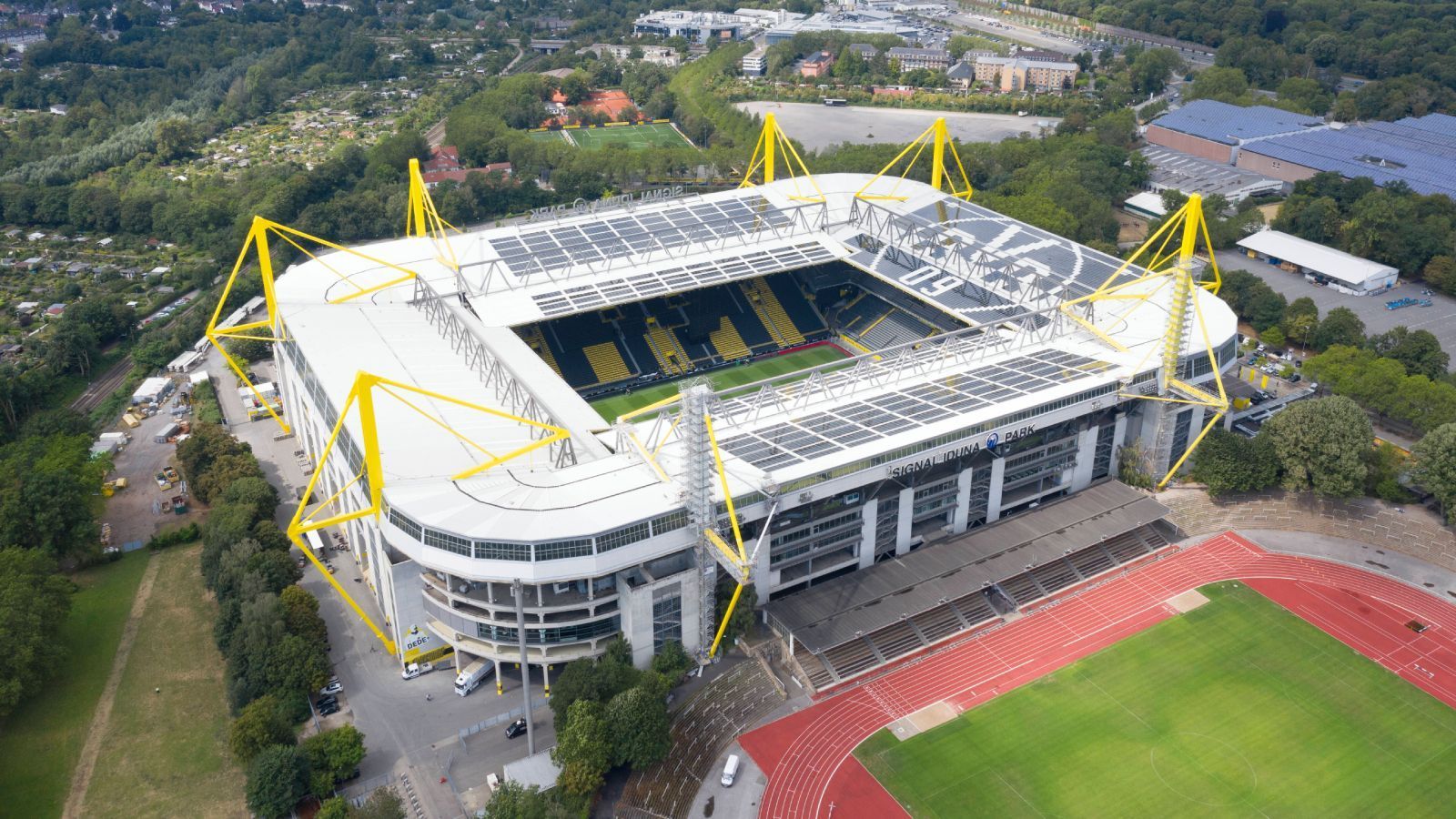 
                <strong>Platz 3: Signal Iduna Park (Borussia Dortmund)</strong><br>
                Der Signal Iduna Park ist nicht nur das größte Fußballstadion in Deutschland, sondern für viele auch das begeisterndste. Wenn man auf die Gelbe Wand blickt, wie sie vor dem Spiel kollektiv die Fußballhymne "You'll never walk alone" schmettert, dann ist Gänsehaut beinahe garantiert. Trotz des Alters schafft das Westfalenstadion es, die Zuschauer nah ans Spielfeld zu bringen. Und obwohl es recht verwinkelt ist, hat man von überall noch einen sehr guten Blick. Das Stadion hat neben den vielen Parkplätzen, die rund um Arena und Westfalenhalle verteilt sind, auch noch eine eigene Haltestelle für Regionalbahnen. Für die gute Ankunft und Abfahrt von 80.000 Zuschauern alle zwei Wochen ist also gesorgt.
              