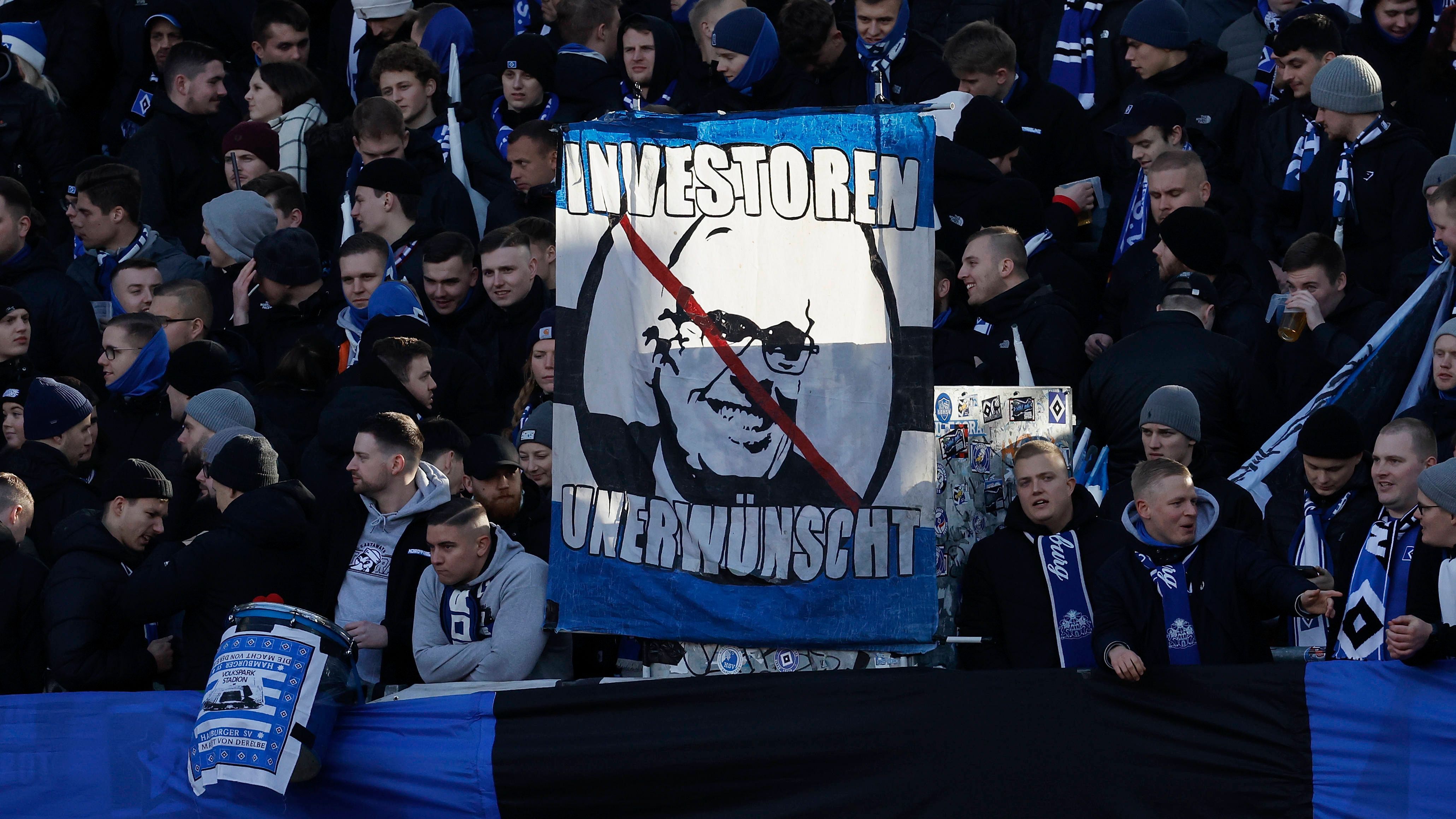 <strong>HSV-Fans lehnen Kühne ab</strong><br>In der Kurve der Gästefans wird ein Banner präsentiert, dass das durchgestrichene Konterfei von HSV-Gönner Klaus-Michael Kühne zeigt. Dazu ist "Investoren unerwünscht" zu lesen.