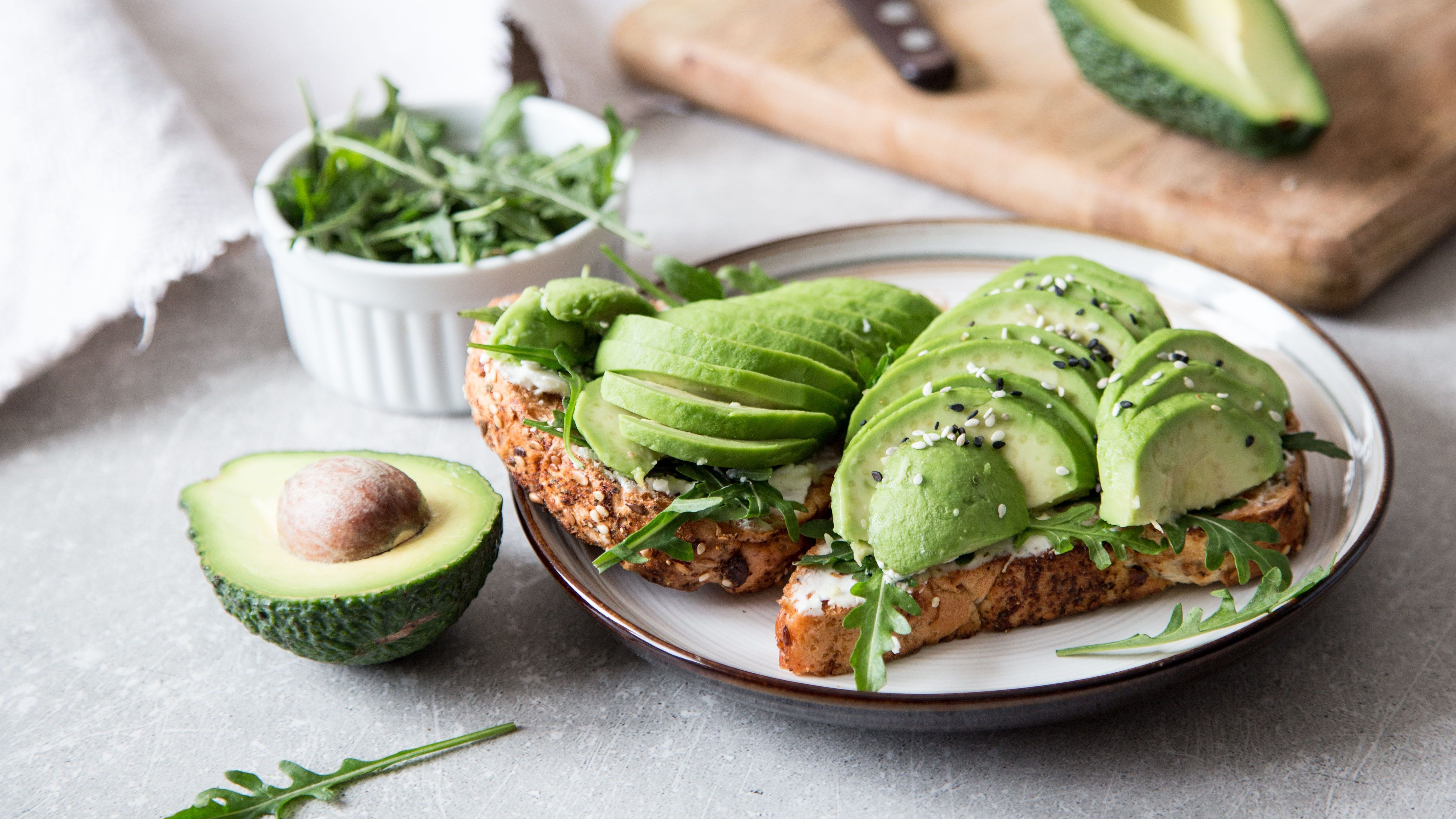 In der Menstrautionsphase solltest du auf gesunde Fette und eisenhaltige Lebensmittel setzen: Ein Avocadobrot mit Rucola ist genau das richtige.