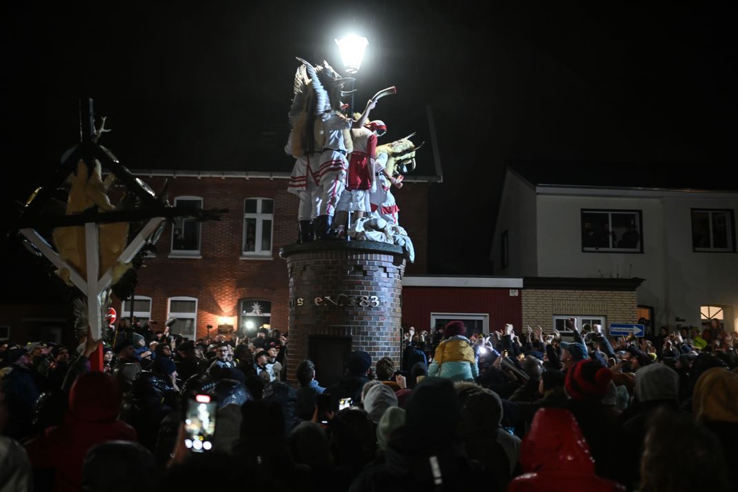 Die Klaasohms erklimmen die Säule des Vereins Borkumer Jungens. Nikolaus-Tradition "Klaasohm" auf der Nordseeinsel Borkum.