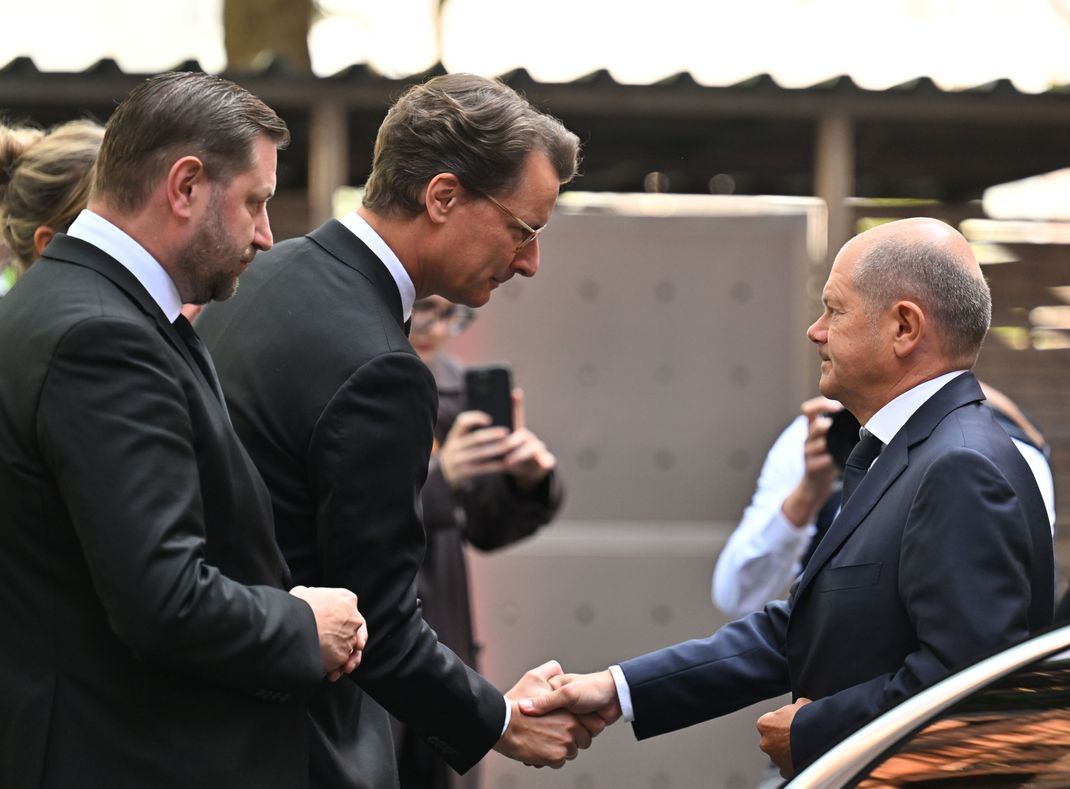 Hendrik Wüst (Mitte) begrüßt Bundeskanzler Olaf Scholz (rechts) in Solingen.