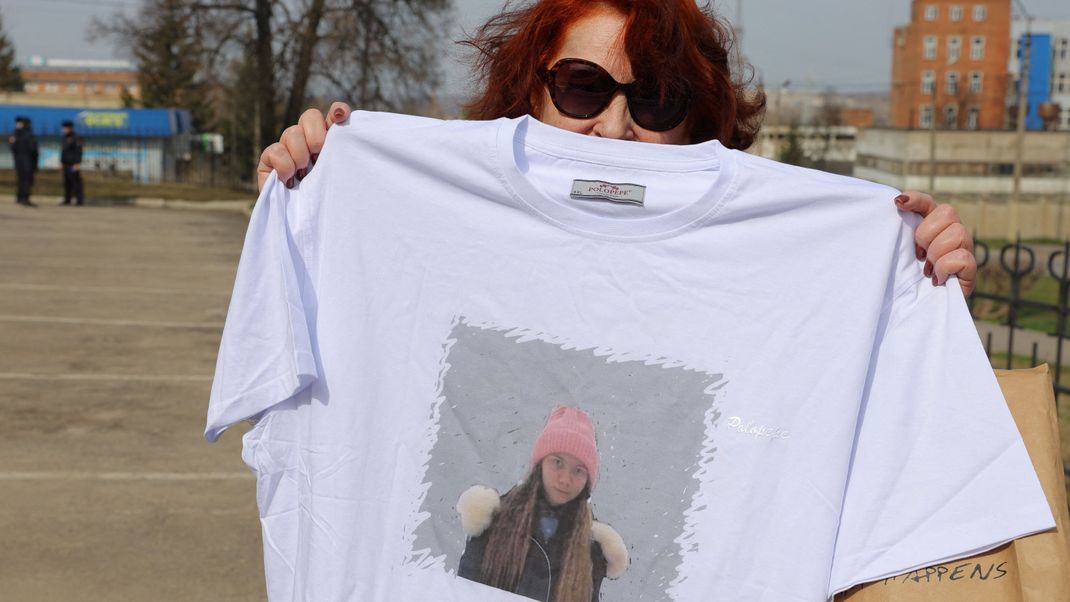 Eine Unterstützerin hält ein T-Shirt mit einem Porträt von Moskaljows Tochter Mascha.