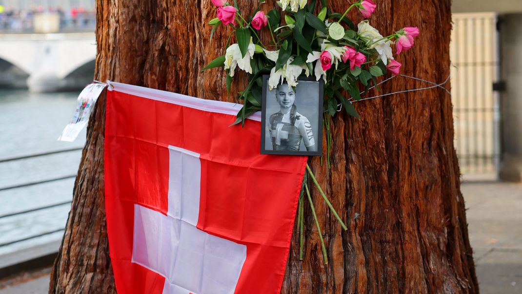 Blumen und eine Schweizer Flagge an einem Baum als Hommage an die tödlich verunglückte Muriel Furrer.