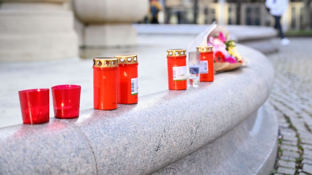 Mannheim: Kerzen und Blumen sind in der Nähe des Paradeplatzes an einem Brunnen platziert. Am Vortag war hier ein Auto in eine Menschenmenge gefahren.