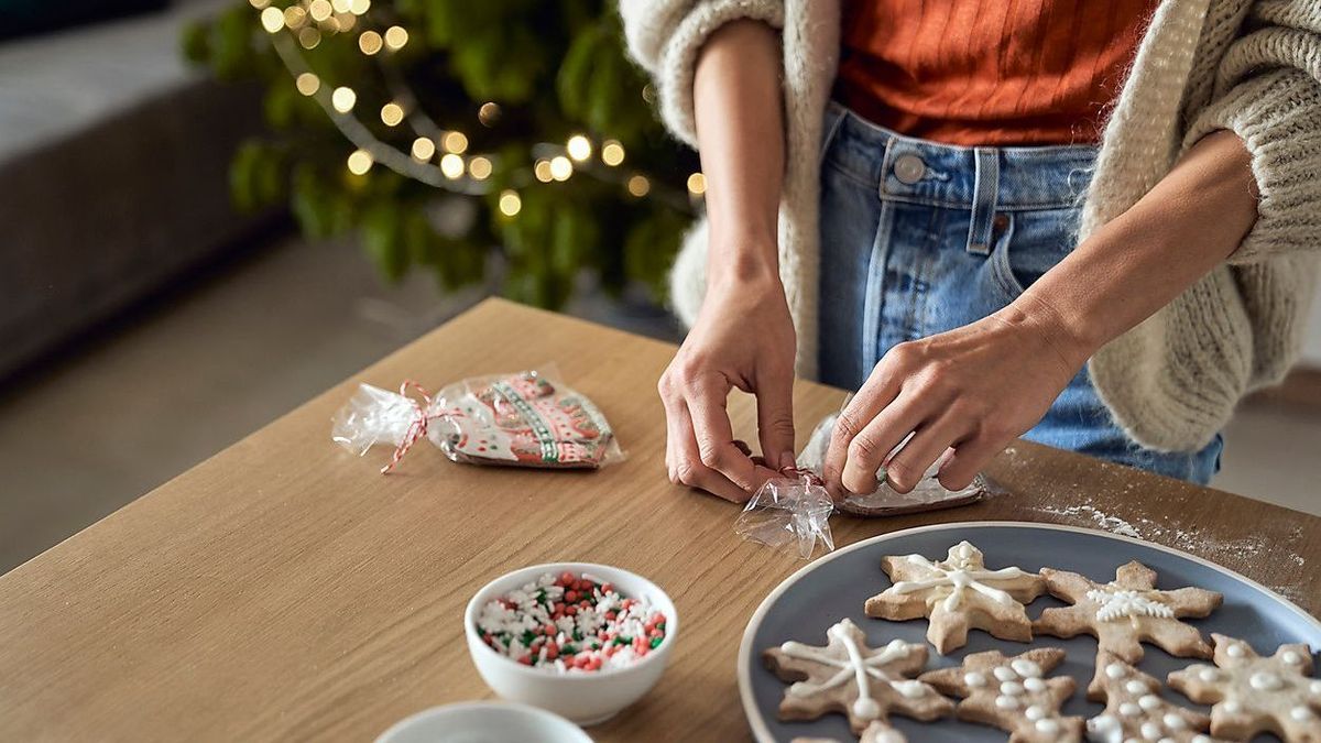 Woman packing gingerbread cookie on table