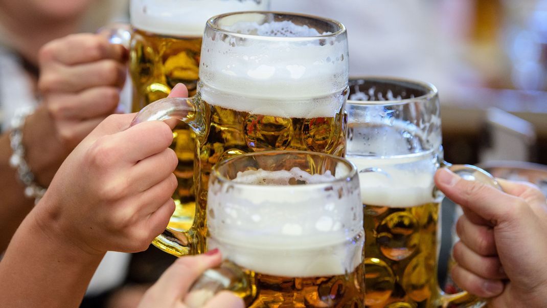 Besucher stoßen auf dem Münchner Oktoberfest mit Bier an.